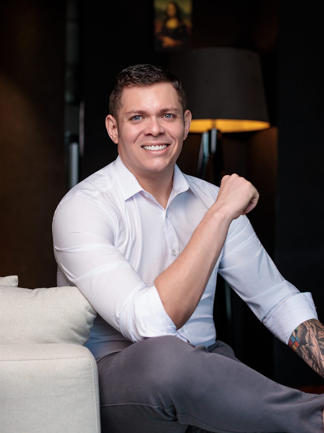 Renan Souza, psicólogo e neuropsicólogo, sorrindo e sentado, de camisa branca